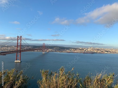 A statue of Cristo Rey and a view of the bridge named April 25 in Lisbon, Portugal.