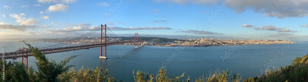 A statue of Cristo Rey and a view of the bridge named April 25 in Lisbon, Portugal.
