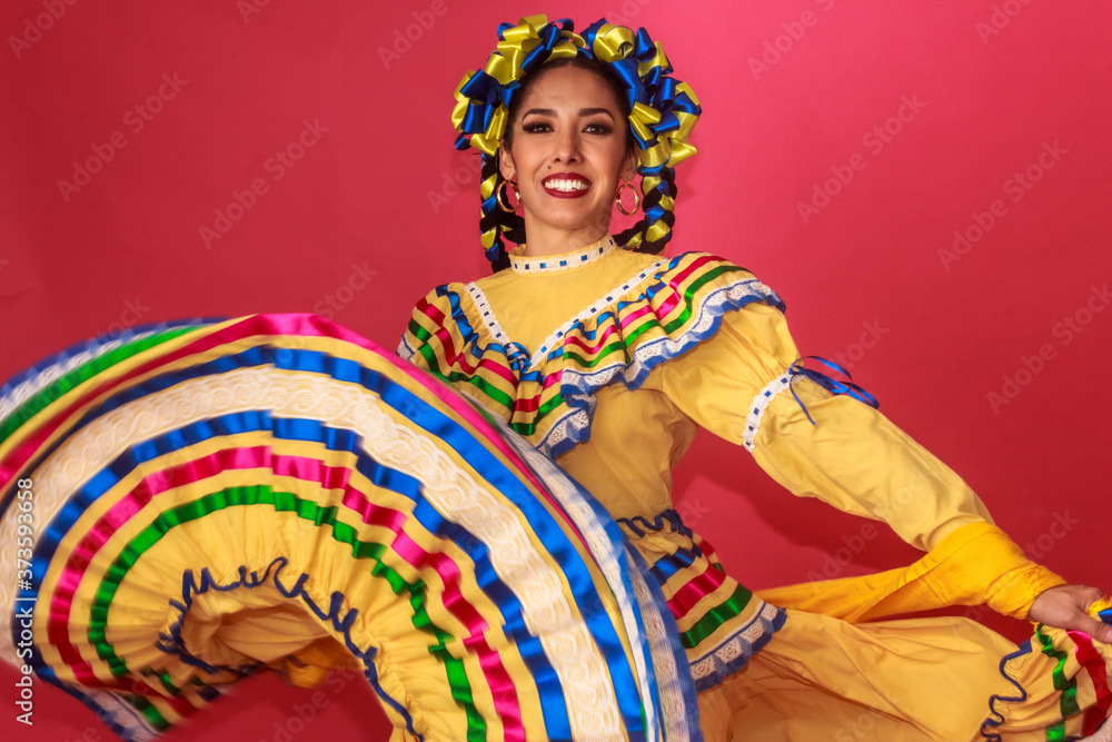Bailarina vestida en traje tradicional folclórico mexicano amarillo en fondo rosa retrato