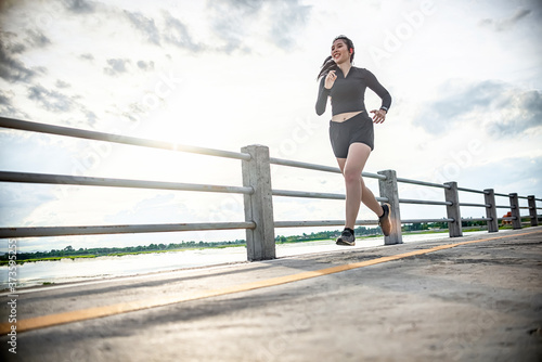 runner - woman running outdoors training for Exercise run.At the bridge at sunset.