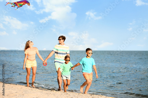 Happy family flying kite on...