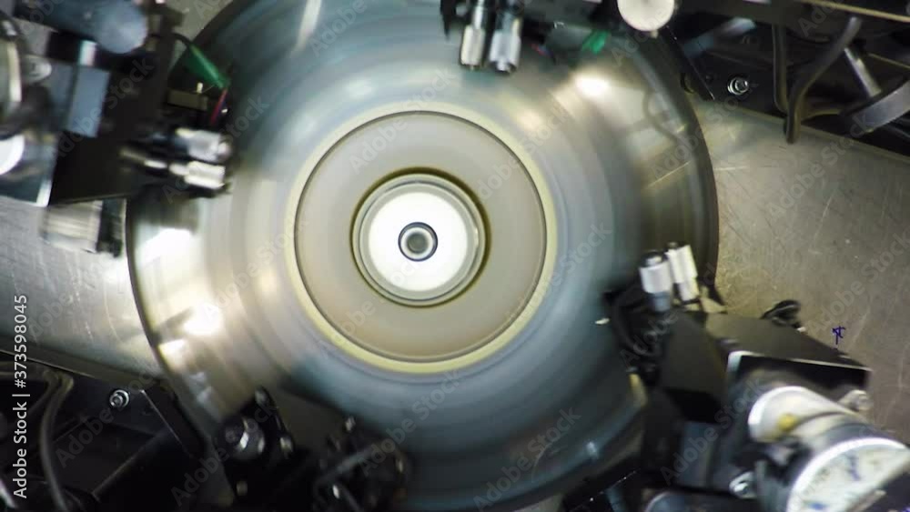 Top view of an automatic bruting machine used in diamond industry, operated by an African woman with a loupe Top view of an automatic bruting machine used in diamond industry, operated by an African woman with a loupe