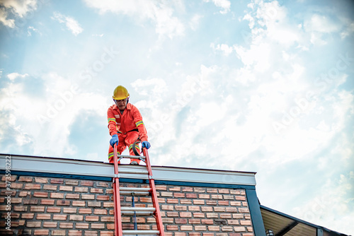 Wallpaper Mural Climbing the risks of a worker by ladder to work on the roof of a house on a beautiful sunny day. Torontodigital.ca