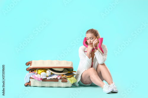 Sad young woman and suitcas...