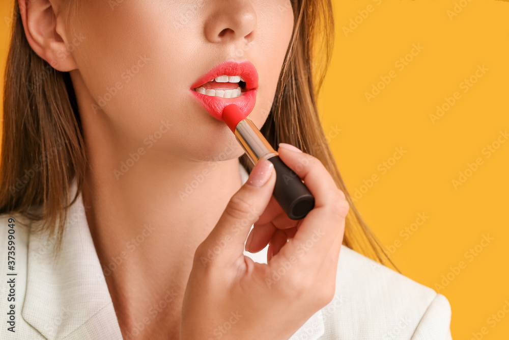 Beautiful young woman with lipstick on color background, closeup Beautiful young woman with lipstick on color background, closeup
