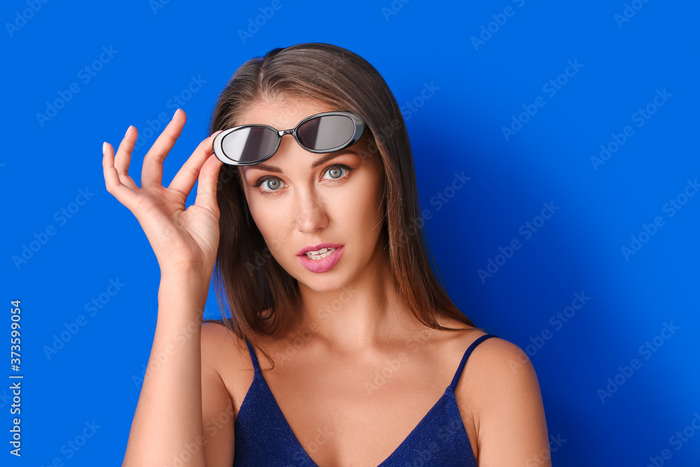 Young woman with beautiful makeup on color background