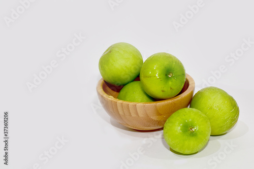 Closeup of Fresh Green jujube in a wooden bowl isolated on white background, Selective Focus.