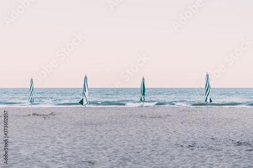 View of four closed beach umbrellas on the shore, Pinamar, Buenos Aires, Argentina. photo