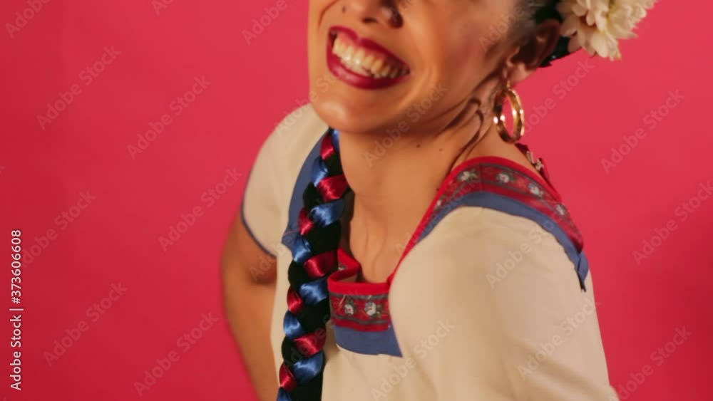 Joven mujer mexicana latina en traje regional folclórico en fondo rosa Joven mujer mexicana latina en traje regional folclórico en fondo rosa
