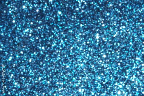 blue Sparkling Lights Festive background with texture. Abstract Christmas twinkled bright bokeh defocused and Falling stars. Winter Card or invitation	