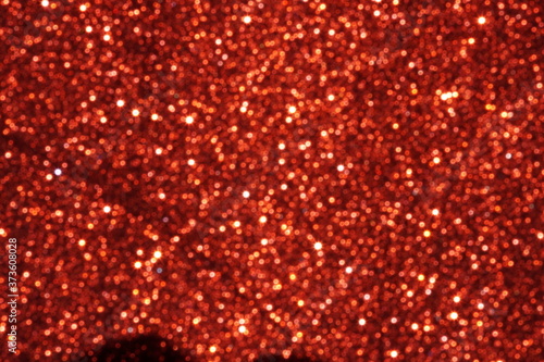 red Sparkling Lights Festive background with texture. Abstract Christmas twinkled bright bokeh defocused and Falling stars. Winter Card or invitation	