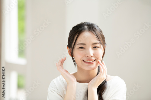 Free Download お肌の調子を気にして微笑む若い日本人女性 6 ズーム - GFXLoad