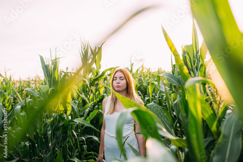 sad red-haired girl in a cornfield