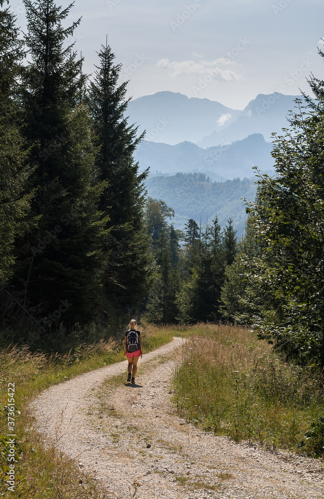 Beauty young woman walking, hiking on Austria Alps mountain path landscape