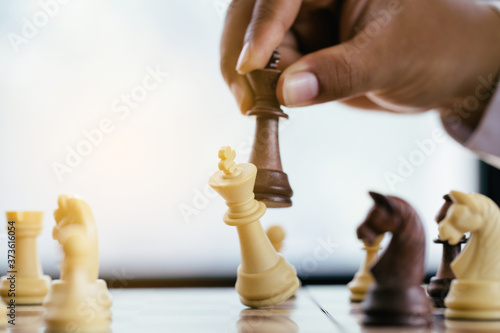 businessman hand moving chess figure in competition success play. strategy,leader and teamwork concept for success.