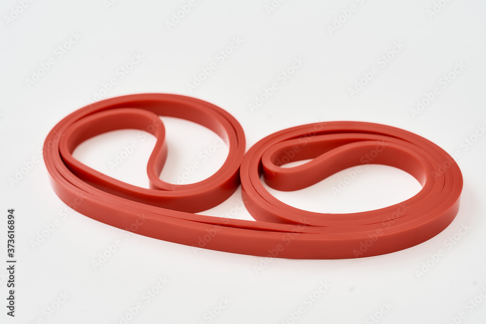 Elastic expander. Red resistance band for fitness isolated on grey background Elastic expander. Red resistance band for fitness isolated on grey background