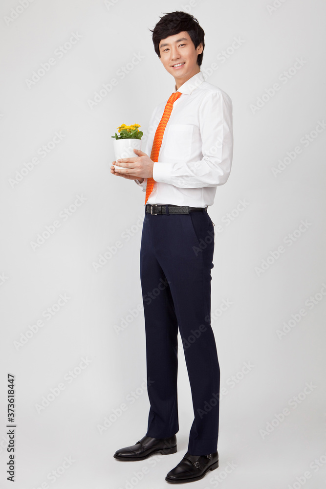 young businessman holding a flowerpot young businessman holding a flowerpot