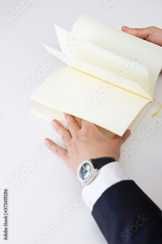 businessman turning a page of blank book