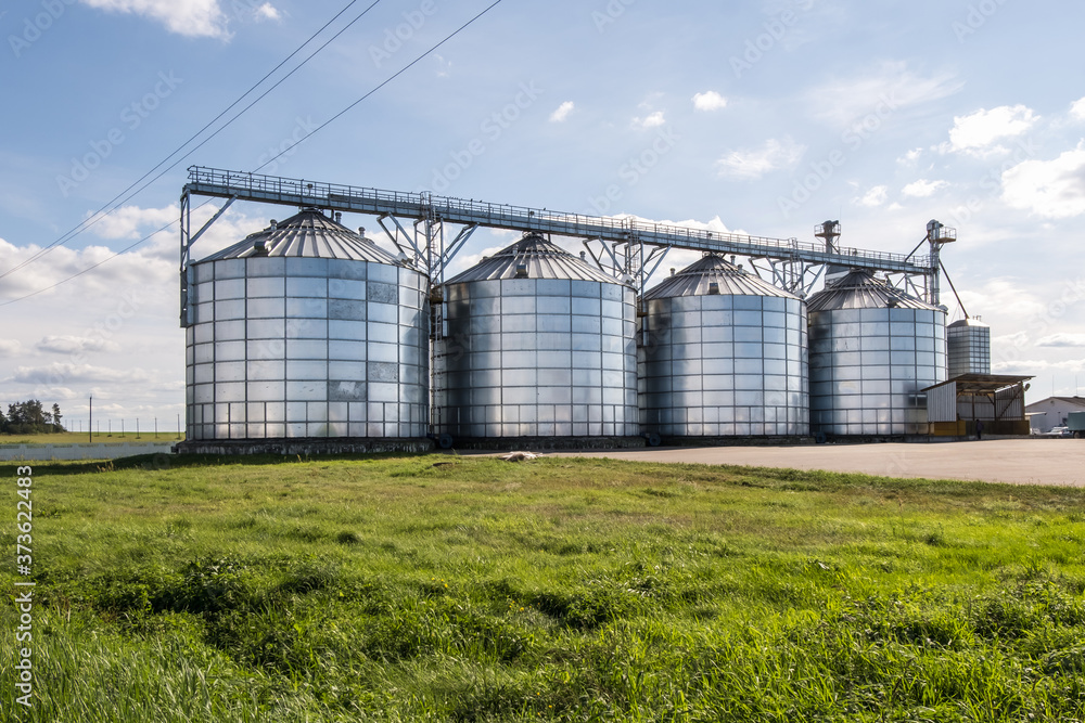 Modern Granary elevator. Silver silos on agro-processing and manufacturing plant for processing drying cleaning and storage of agricultural products, flour, cereals and grain. Modern Granary elevator. Silver silos on agro-processing and manufacturing plant for processing drying cleaning and storage of agricultural products, flour, cereals and grain.