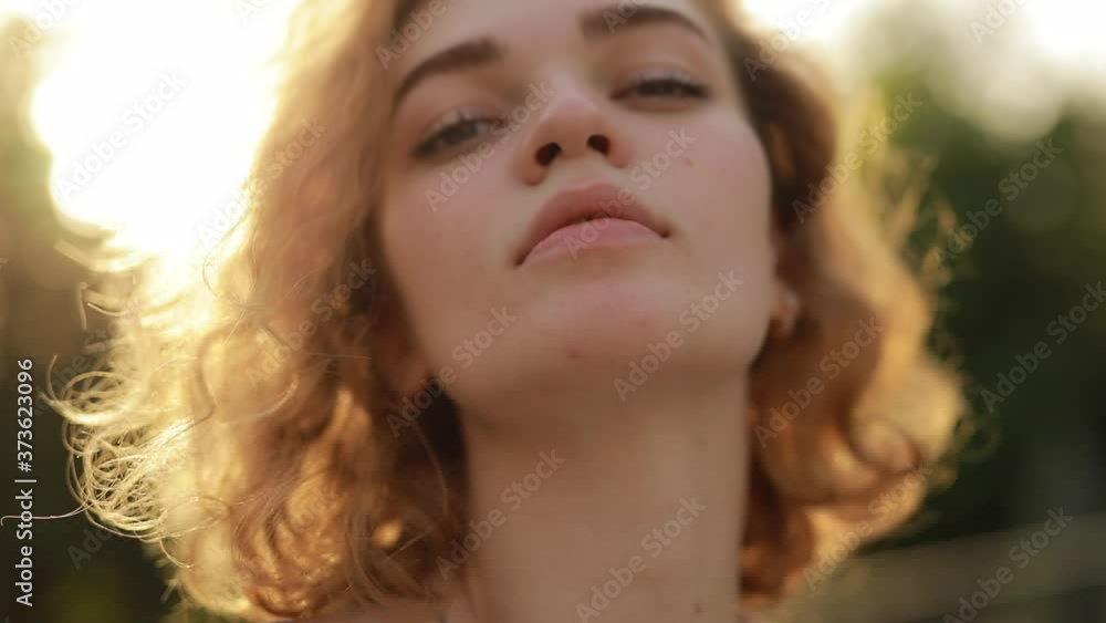 Pretty attractive curly hair woman model looking at camera in the summer park Pretty attractive curly hair woman model looking at camera in the summer park