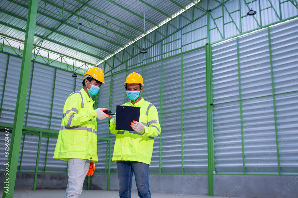 Asian Industrial Engineer in Hard Hat Wearing Safety Jacket plan work with warehouse workers Processes in the factory. Asian Industrial Engineer in Hard Hat Wearing Safety Jacket plan work with warehouse workers Processes in the factory.