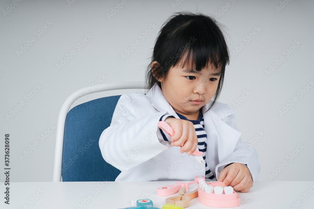 Asian thai kid play role as a dentist brushing teeth with toothbrush. Asian thai kid play role as a dentist brushing teeth with toothbrush.