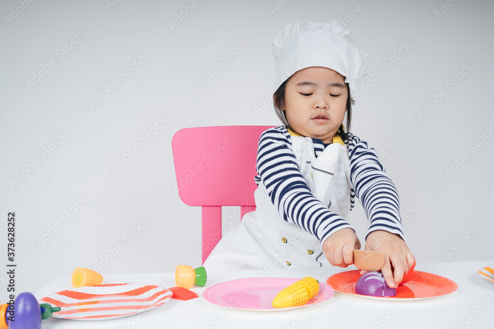 Asian thai kid play role as a chef cooking in kitchen. Asian thai kid play role as a chef cooking in kitchen.