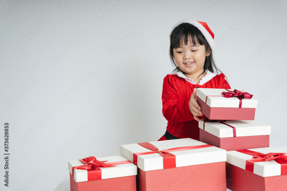 Pretty asian thai kid woman in santa claus uniform with christmas gift box for celebrating. Pretty asian thai kid woman in santa claus uniform with christmas gift box for celebrating.