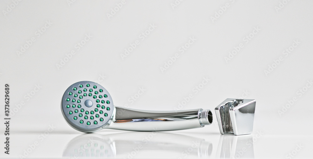 Obraz premium New shiny shower head and wall mount for it. On a light background. Materials for plumbing works.