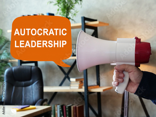 Autocratic leadership concept. Loudspeaker in hand and inscription.