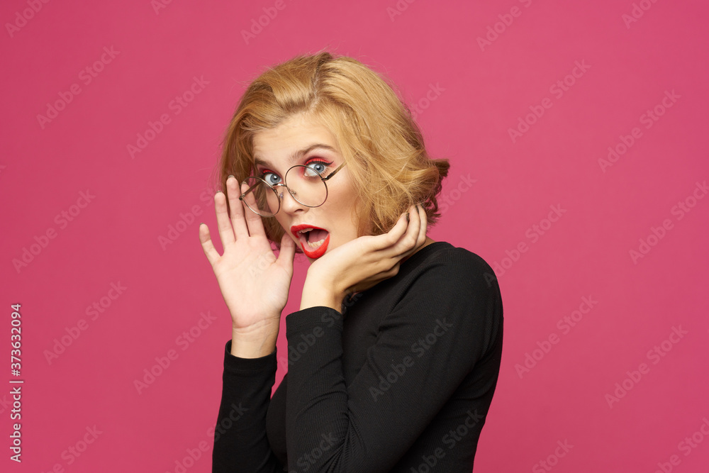 Pretty woman in black sweater short hairstyle glasses pink isolated background Pretty woman in black sweater short hairstyle glasses pink isolated background