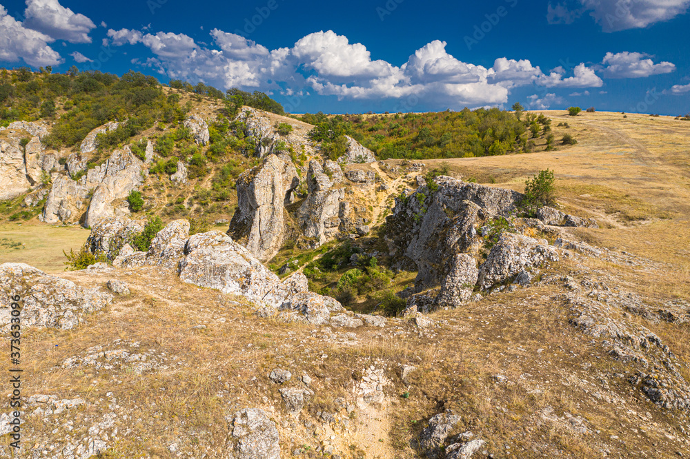 Aerial view over Dobrogei Gorges road and rock landscape from Constanta, Romania - amazing landmark with blue sky and white clouds