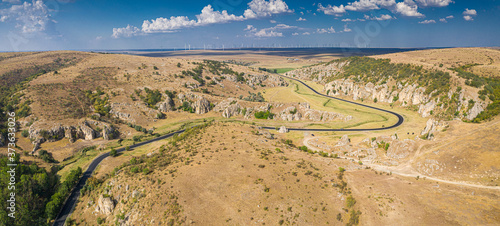 Aerial view over Dobrogei Gorges road and rock landscape from Constanta, Romania - amazing landmark with blue sky and white clouds photo