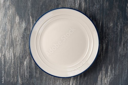 White plate with blue border on a beautiful gray wooden background