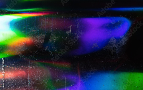 Abstract background of holographic strings of all rainbow colors with dust and scratches.