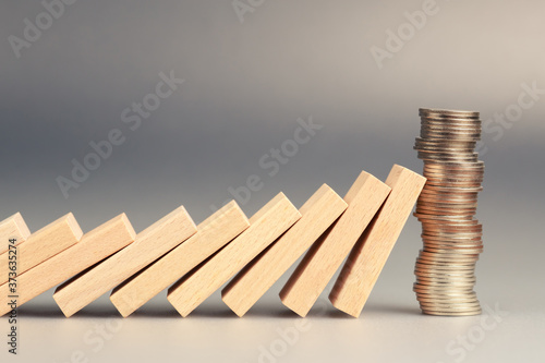 Money coins heap still balance and stop the falling domino, financial stability concept photo