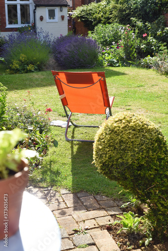 Relaxing area in garden with a deck chair on the lawn during a sunny day