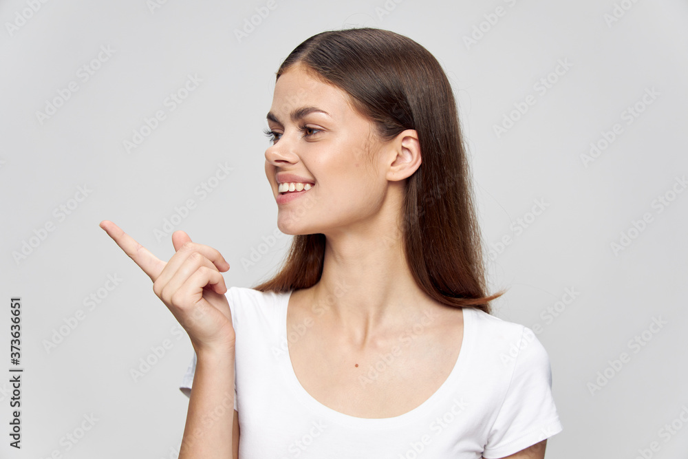 Girl in a white T-shirt show a finger to the side And smile Girl in a white T-shirt show a finger to the side And smile