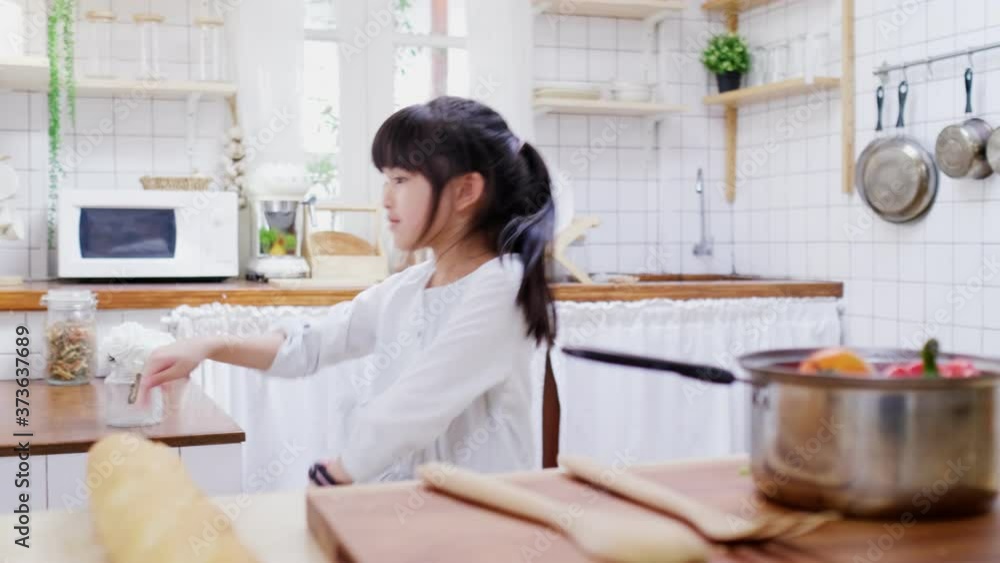 Little cute young Asian girl dancing in kitchen at home. Little cute young Asian girl dancing in kitchen at home.