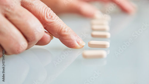 Patient zeigt mit dem Finger auf Tabletten