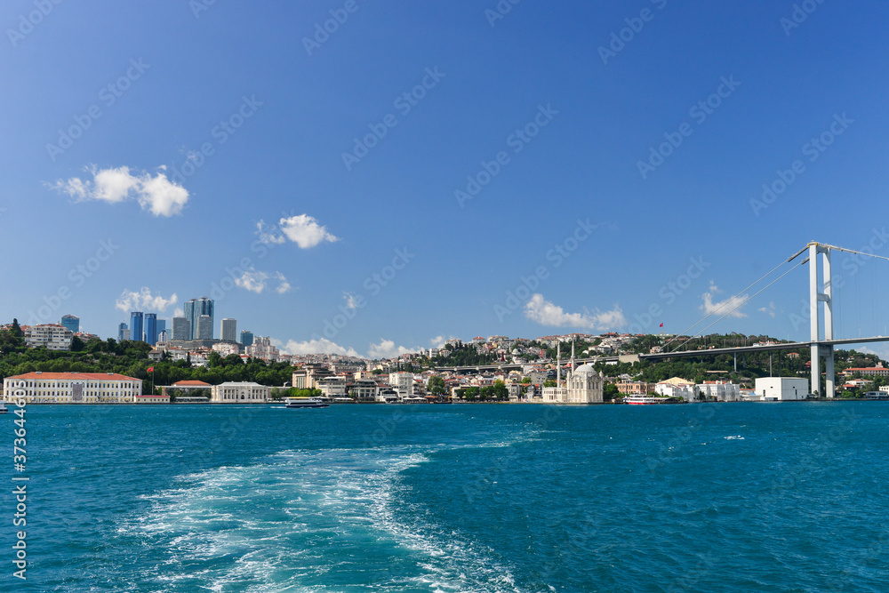 Istanbul cityscape, including Bosphorus bridge and Ortakoy Mosque as seen from a passenger boat - Istanbul, Turkey