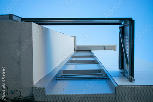 Fachada de edificio de pisos visto desde el hueco del tendedero hacia el cielo