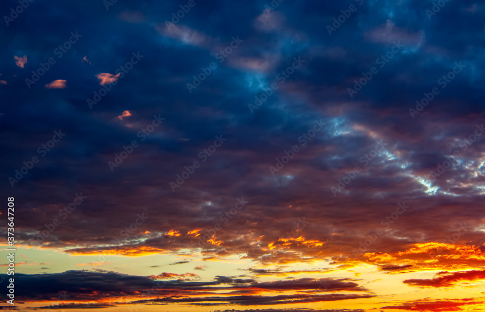 Obraz premium Panorama of the evening sky with dramatic orange, purple and dark blue clouds. Background image