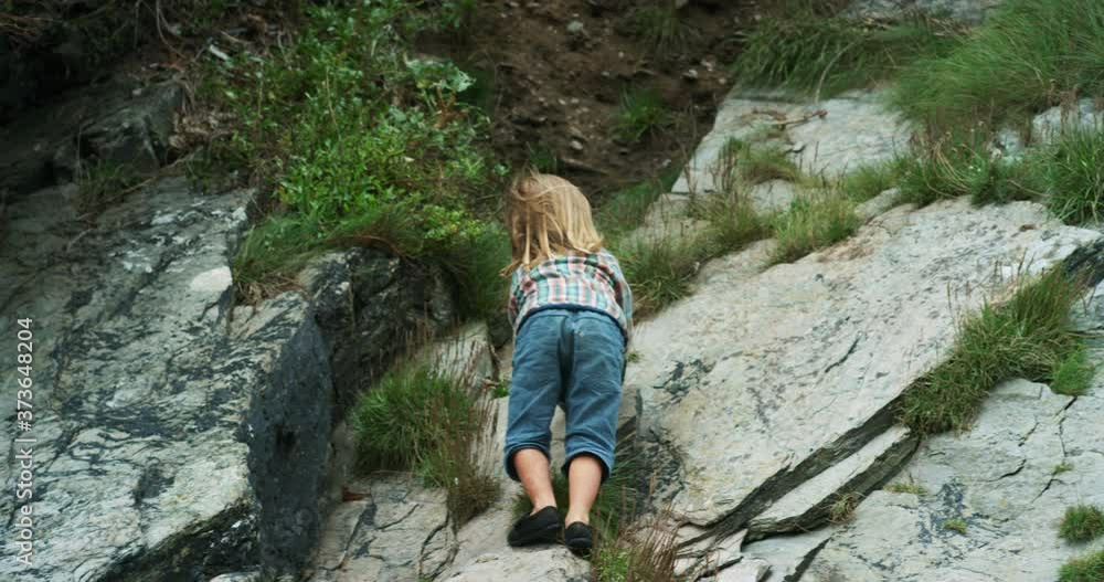 Preschooler climbing on rocks in nature Preschooler climbing on rocks in nature
