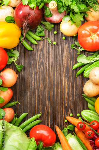 Assortment of fresh vegetables on wooden table frame background. Healthy organic food grocery concept. Copy space