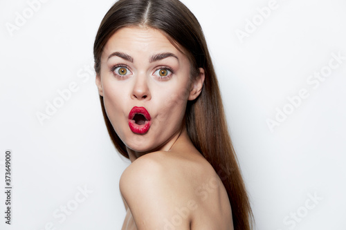 Charming woman With a surprised look, red lips, bare shoulders clear skin light 