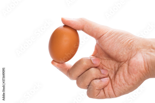 a man's hand hold and show brown chicken egg with two fingers isolated in white background with clipping path