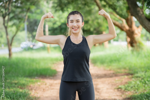Asian women wear workout clothes at the park and are warming their bodies before exercising.
