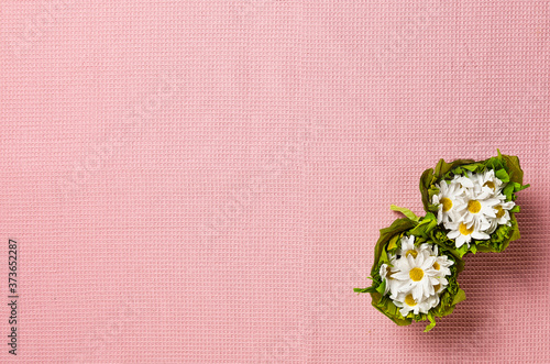 White flowers on Pink tablecloth fabric texture background. Top view