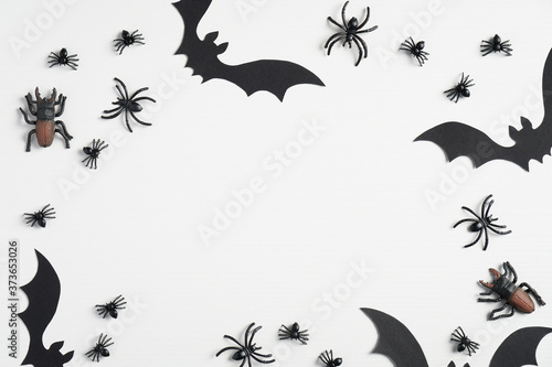 Halloween composition. Frame of halloween decorations  bats and spiders on white background. Flat lay  top view. Happy halloween concept.